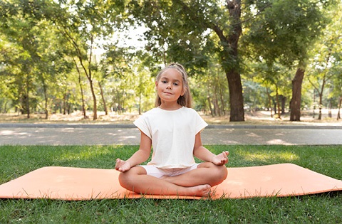 a child sitting in a yoga pose