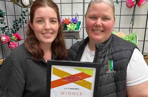 Two women holding an award