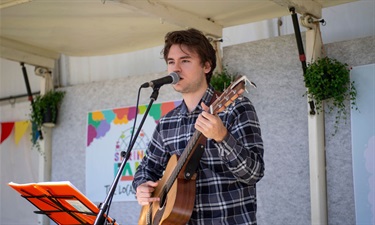 Someone singing and playing an acoustic guitar